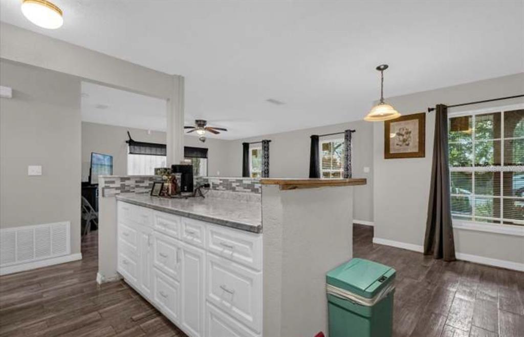 A kitchen with white cabinets, a gray countertop, and a teal trash can — 1783 FLORES COURT, ORLANDO, FL