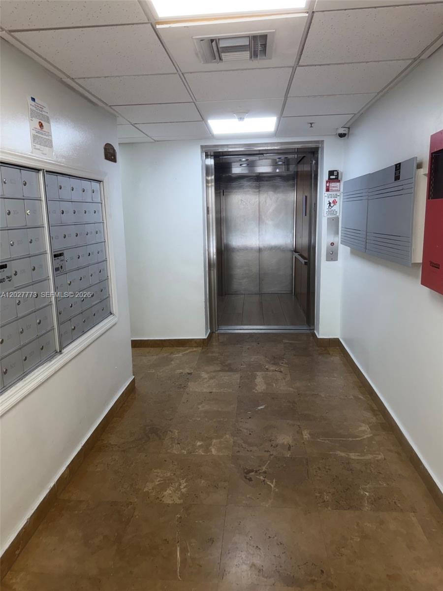 A hallway features a metal elevator, rows of mailboxes, and tiled flooring — 102 SW 6th Ave # 501, Miami FL 33130, MIAMI, FL