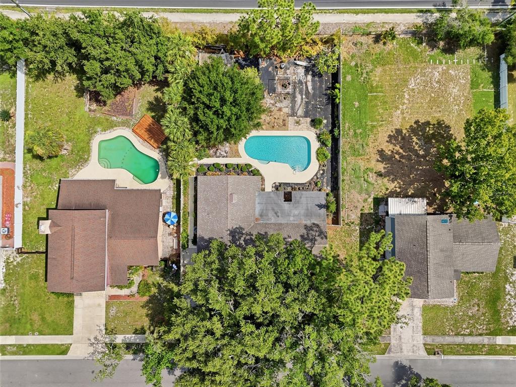 Aerial view of three residential properties featuring two swimming pools and mature trees — 1610 GLADIOLAS DRIVE, WINTER PARK, FL