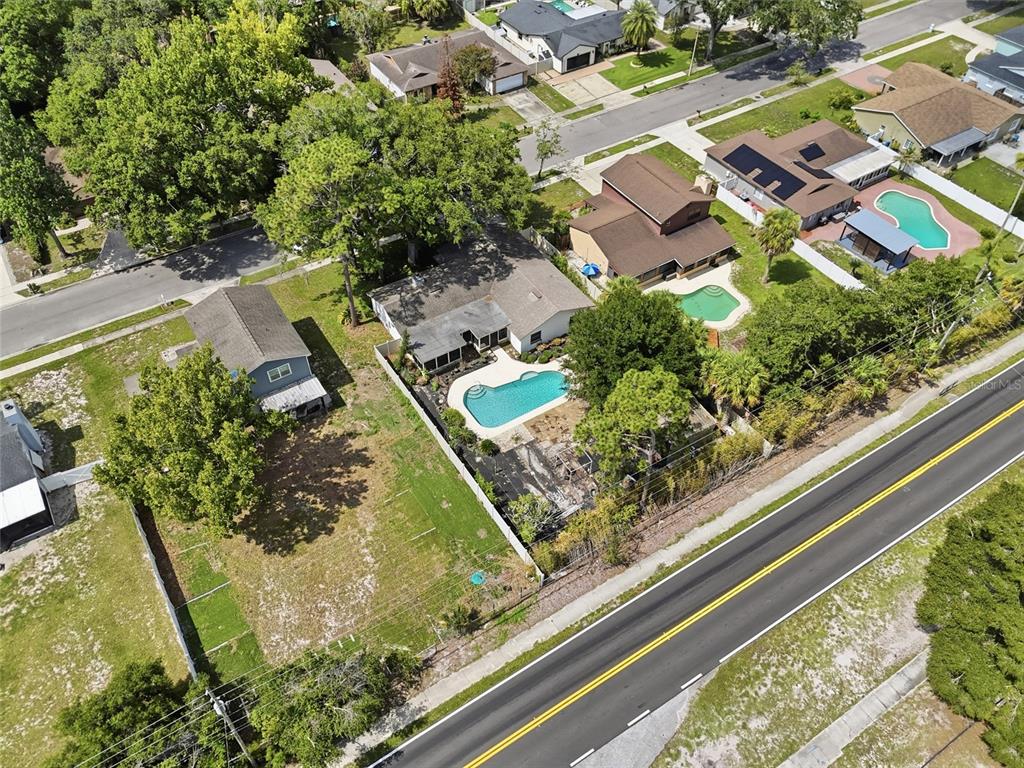 An aerial view shows several suburban houses with swimming pools near a main road — 1610 GLADIOLAS DRIVE, WINTER PARK, FL