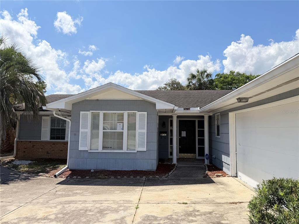 A single-story house with gray siding, a white-trimmed bay window, and an attached garage — 4420 TRAVELERS ROAD, JACKSONVILLE, FL