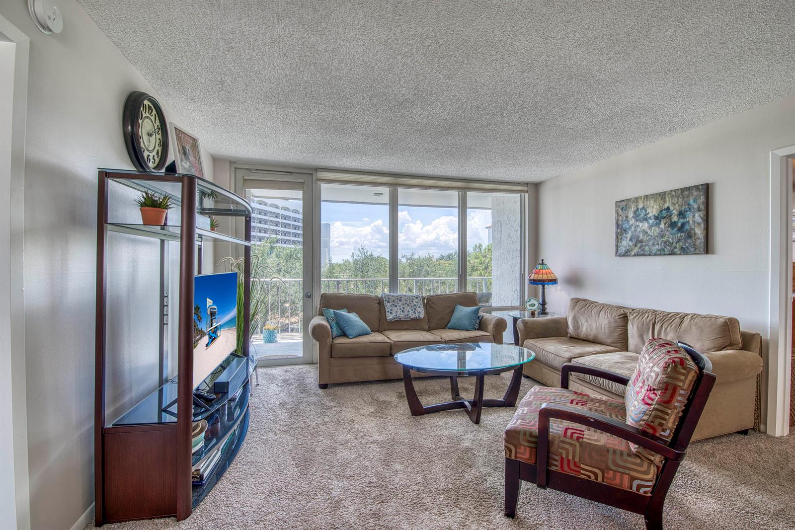 A living room features beige carpet, two sofas, a glass coffee table, and a balcony view — 336 Golfview Road # 518, North Palm Beach FL 33408, NORTH PALM BEACH, FL