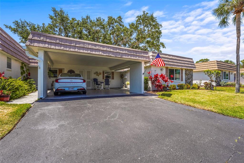 A single-story house with a carport, a parked car, and a front lawn — 2531 RIVERBLUFF PARKWAY UNIT V181, SARASOTA, FL