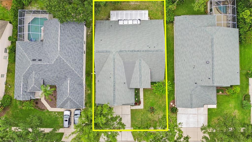 An aerial view shows three suburban houses with gray shingled roofs and green lawns — 10217 TIMBERLAND POINT DRIVE, TAMPA, FL