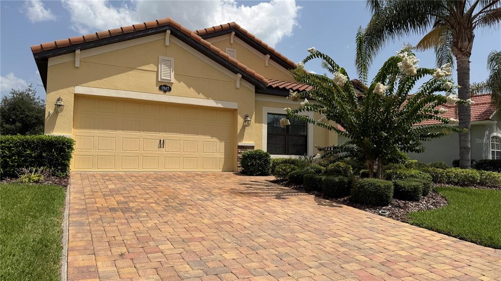 A yellow stucco house with a tiled roof and a paved driveway — 1947 ALTAVISTA CIRCLE, LAKELAND, FL