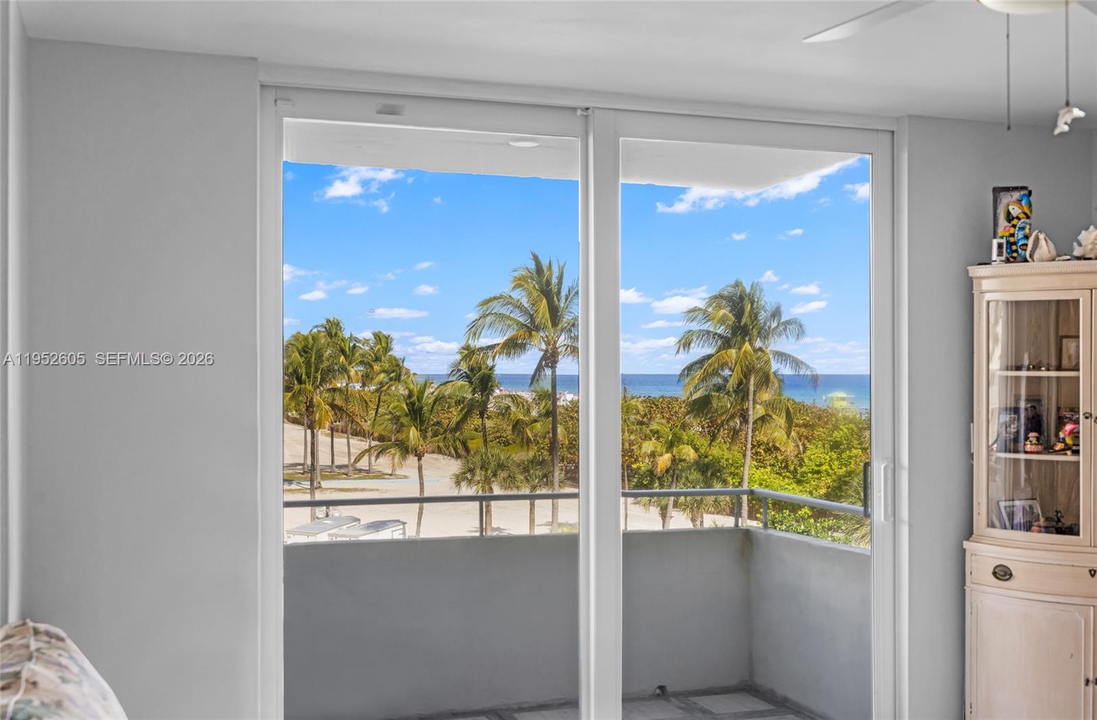 A view of a beach and ocean through a sliding glass door from a room — 465 Ocean Dr # 419, Miami Beach FL 33139, MIAMI BEACH, FL