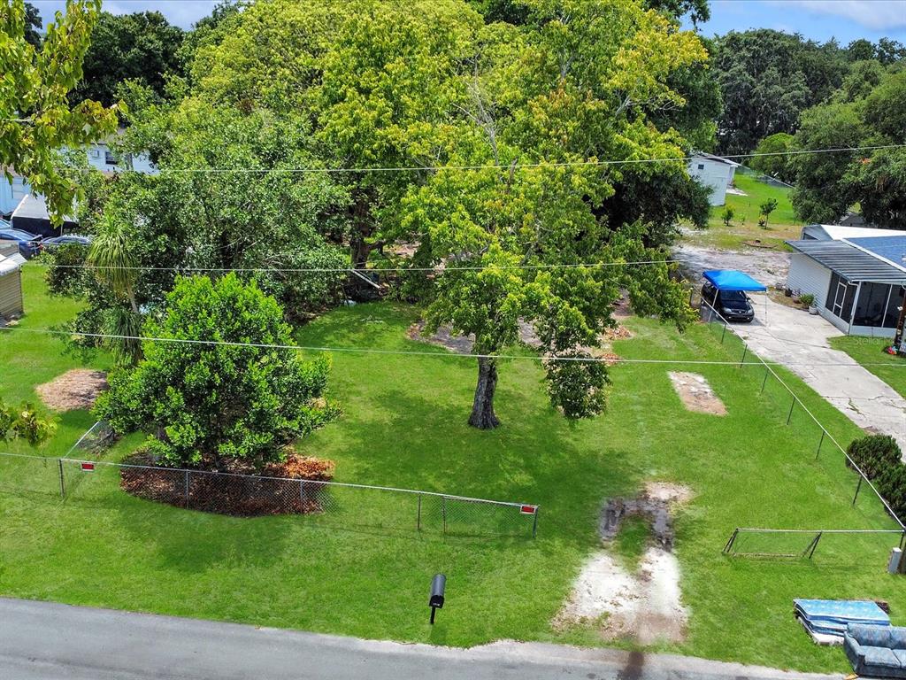 An aerial view shows a fenced, grassy residential lot with several large trees — 2824 BAY AVENUE, KISSIMMEE, FL
