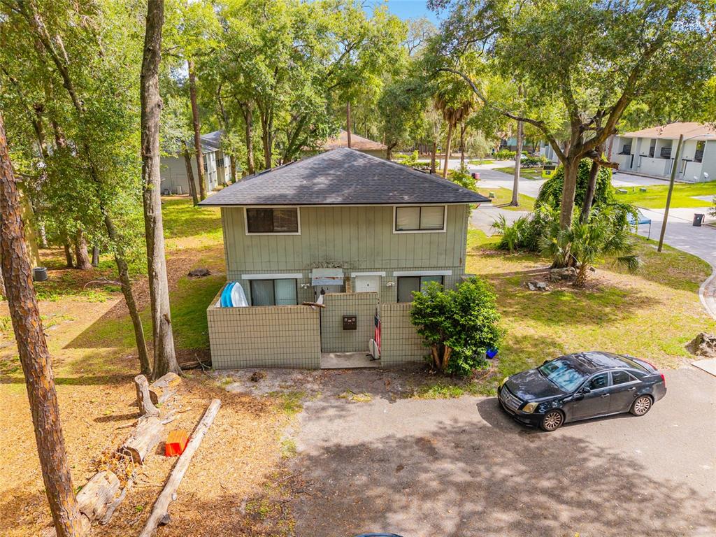 An aerial view of a two-story house with a fenced patio and a parked car — 714 SW 69TH STREET, GAINESVILLE, FL