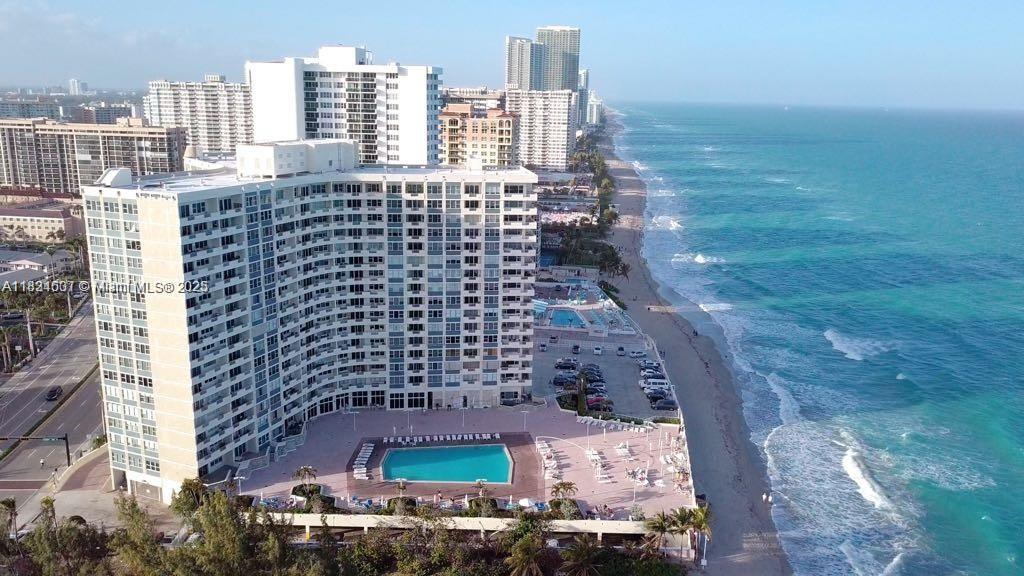 An aerial view of a high-rise beachfront condominium building with a swimming pool and parking lot — 3180 S Ocean Dr # 1602, Hallandale Beach FL 33009, HALLANDALE BEACH, FL