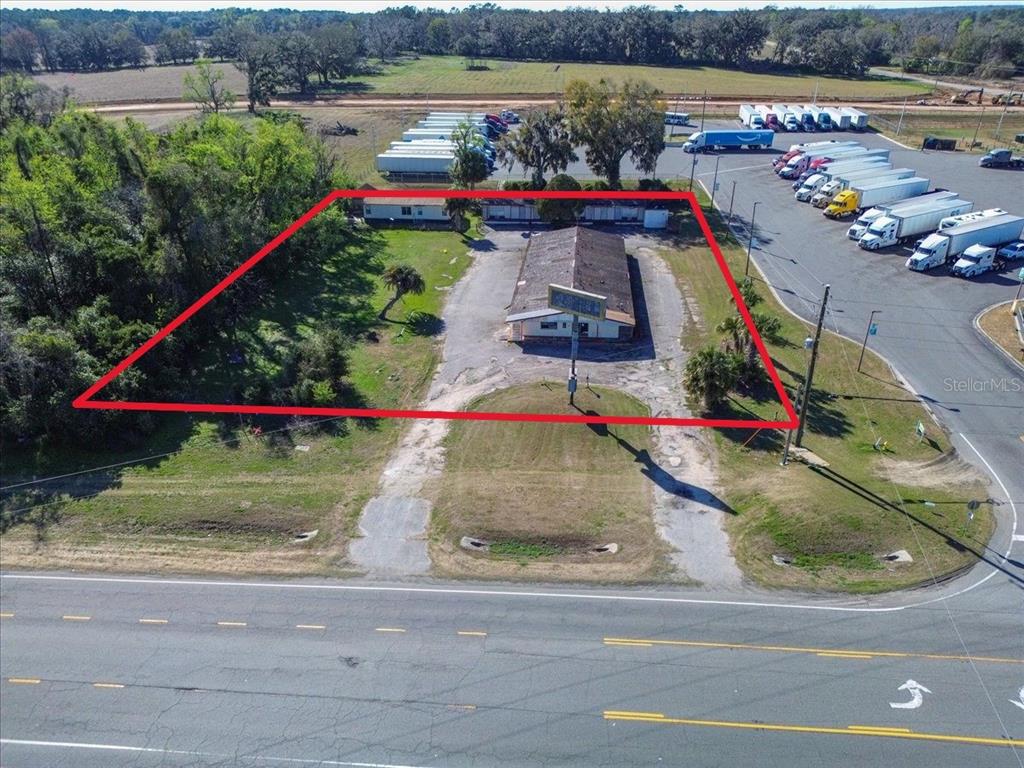 An aerial view shows a commercial building on a lot bordered by a highway — 14240 S US HIGHWAY 441, LAKE CITY, FL