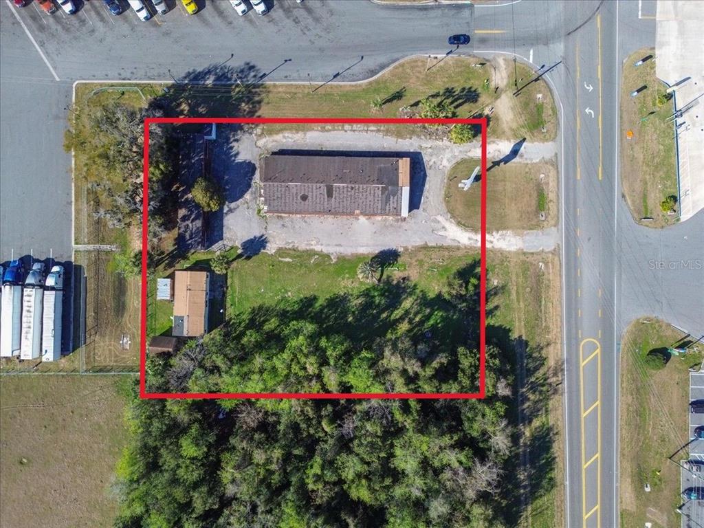 An aerial view shows a rectangular lot containing two buildings and a wooded area — 14240 S US HIGHWAY 441, LAKE CITY, FL