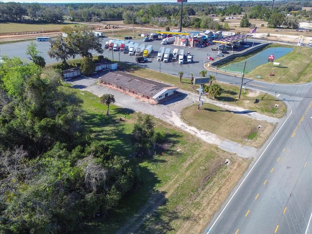 An aerial view shows a dilapidated motel building next to a truck stop and highway — 14240 S US HIGHWAY 441, LAKE CITY, FL