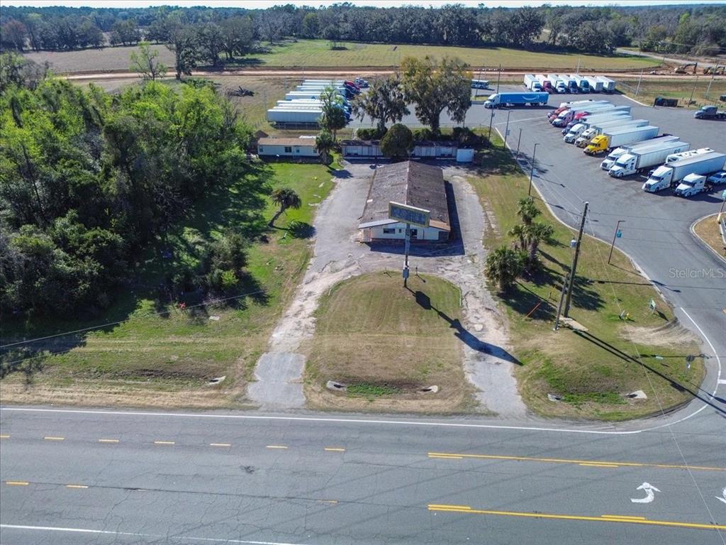 An aerial view shows a commercial building with a large parking lot containing many semi-trailers — 14240 S US HIGHWAY 441, LAKE CITY, FL