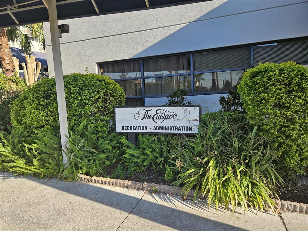 A sign for The Enclave Recreation and Administration building stands in front of a building — 6165 CARRIER DRIVE UNIT 3201, ORLANDO, FL