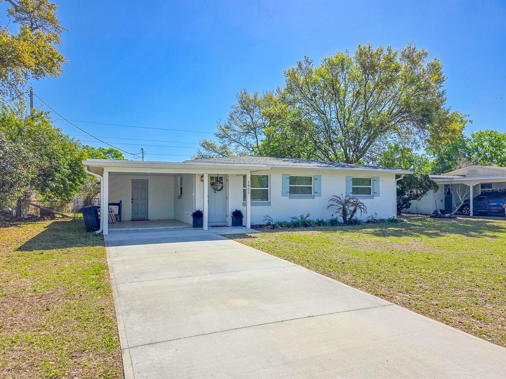 A single-story house with a white exterior, a carport, and a concrete driveway — 1807 GOLFVIEW BOULEVARD, SOUTH DAYTONA, FL