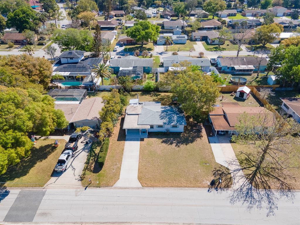 An aerial view shows three suburban houses with driveways, lawns, and trees along a street — 1807 GOLFVIEW BOULEVARD, SOUTH DAYTONA, FL