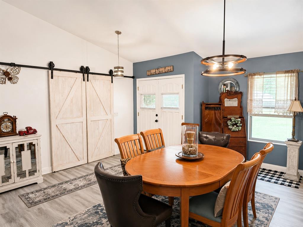 A dining room features a wooden table, barn doors, and a blue accent wall — 12820 NW 116TH PLACE, ALACHUA, FL
