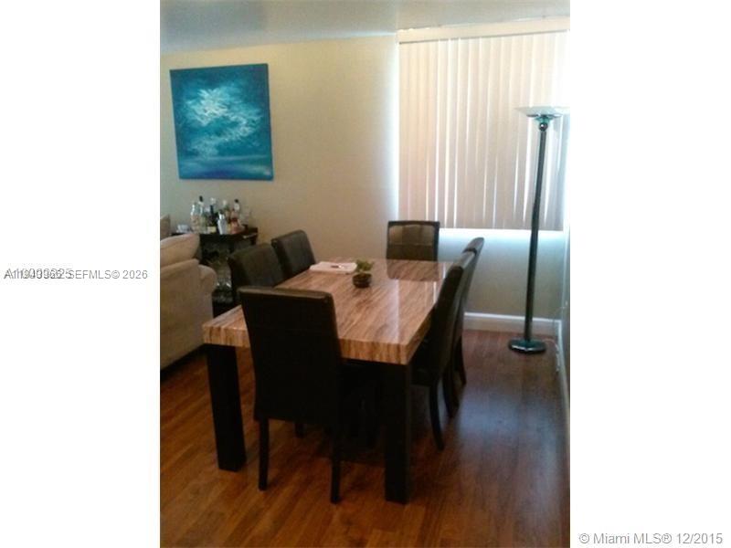 A dining room features a wood-patterned table with dark chairs and a floor lamp — 800 N Miami Ave # 1108, Miami FL 33136, MIAMI, FL