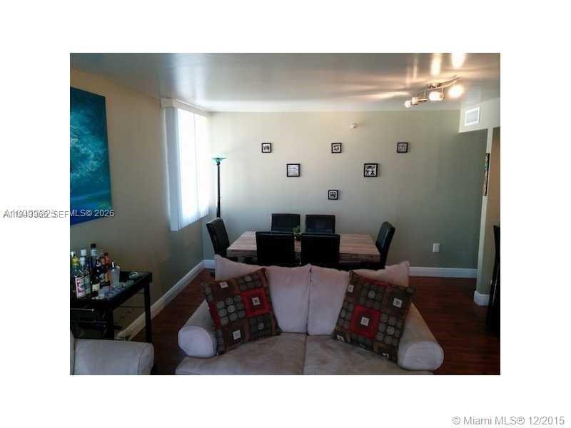 A living room with a sofa, a dining table, and a bar cart on wood floors — 800 N Miami Ave # 1108, Miami FL 33136, MIAMI, FL