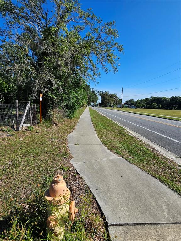 A sidewalk runs alongside a road next to a grassy field and a fire hydrant — 123 W 2ND AVENUE, PIERSON, FL