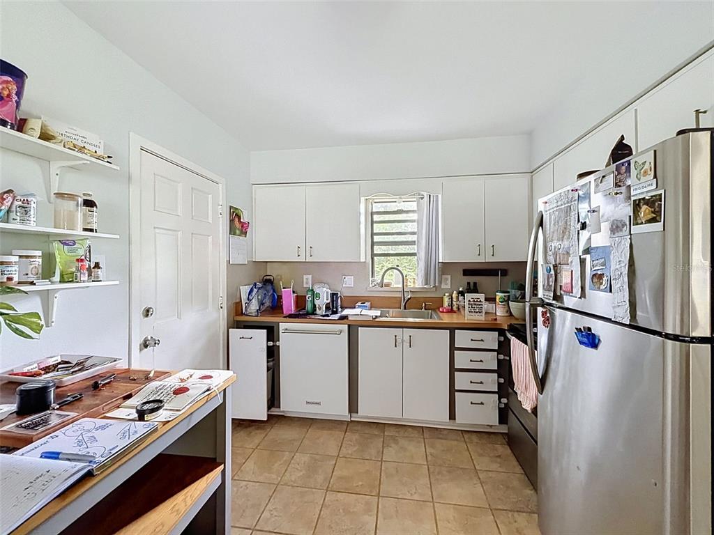 A kitchen features white cabinets, stainless steel appliances, a sink, and a tiled floor — 7995 53RD WAY N, PINELLAS PARK, FL