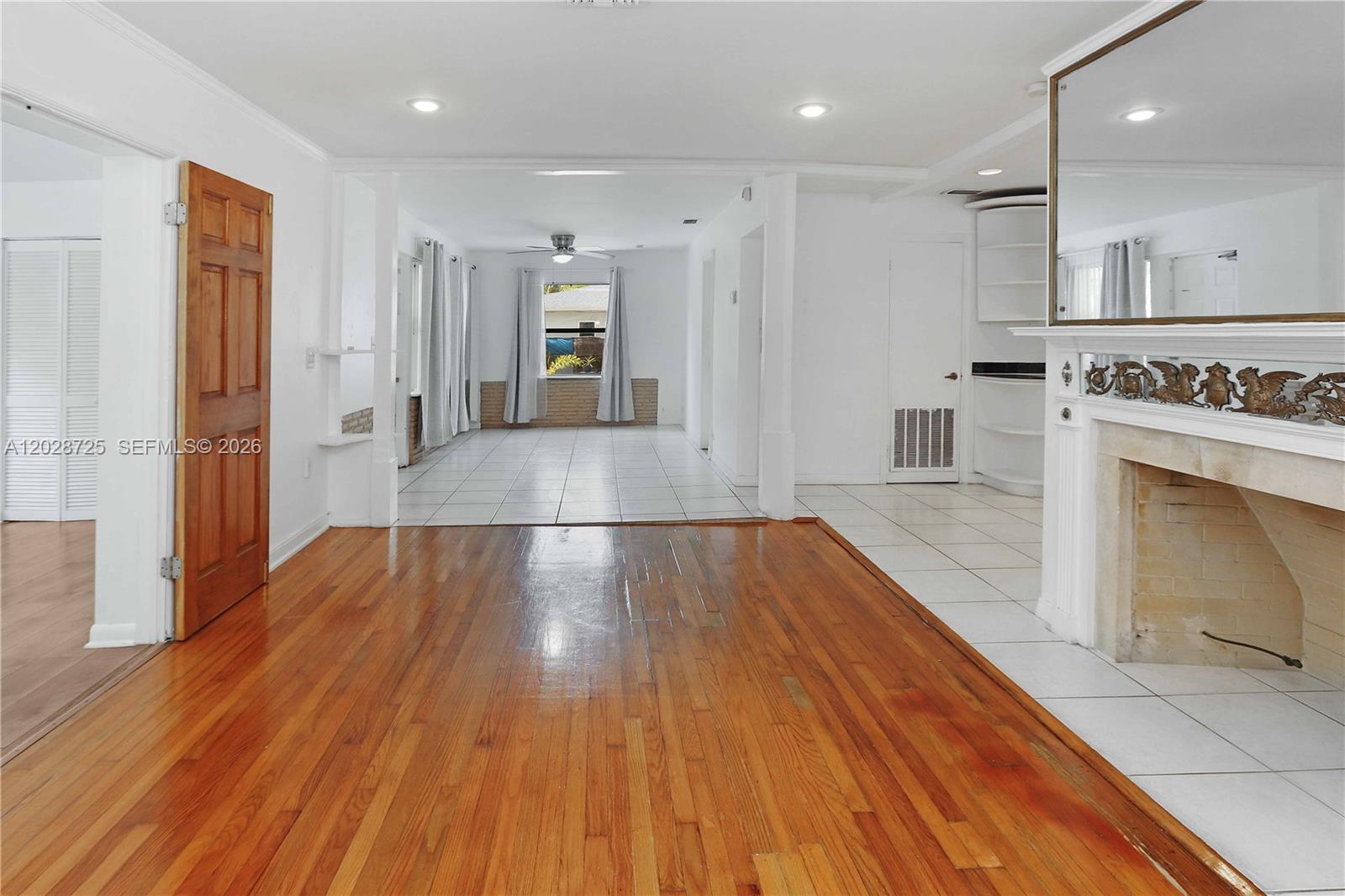 A living area features hardwood floors, a fireplace, and an adjacent tiled dining space — 706 S 19th Ave, Hollywood FL 33020, HOLLYWOOD, FL