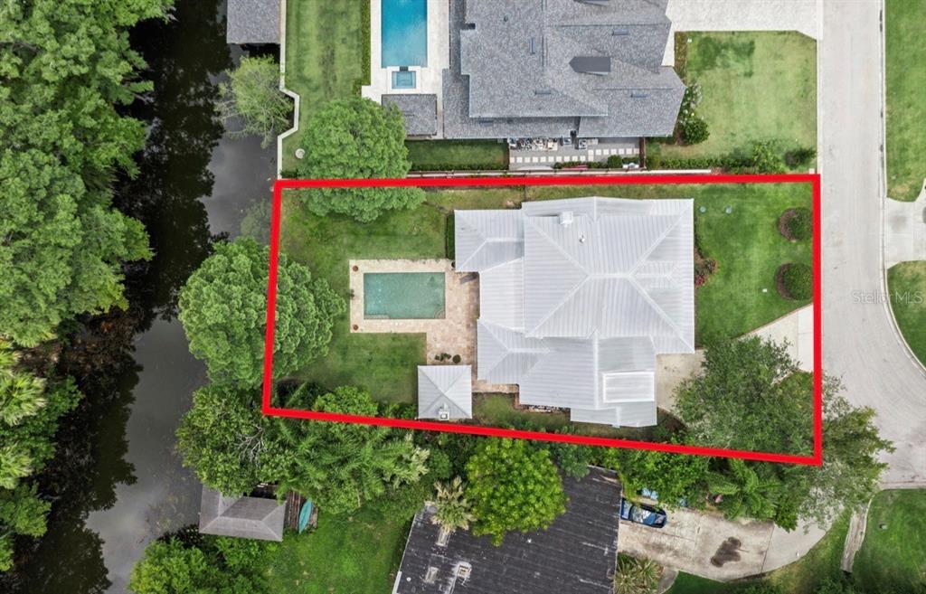 An aerial view shows a house with a metal roof, a pool, and a backyard — 2240 VENETIAN WAY, WINTER PARK, FL
