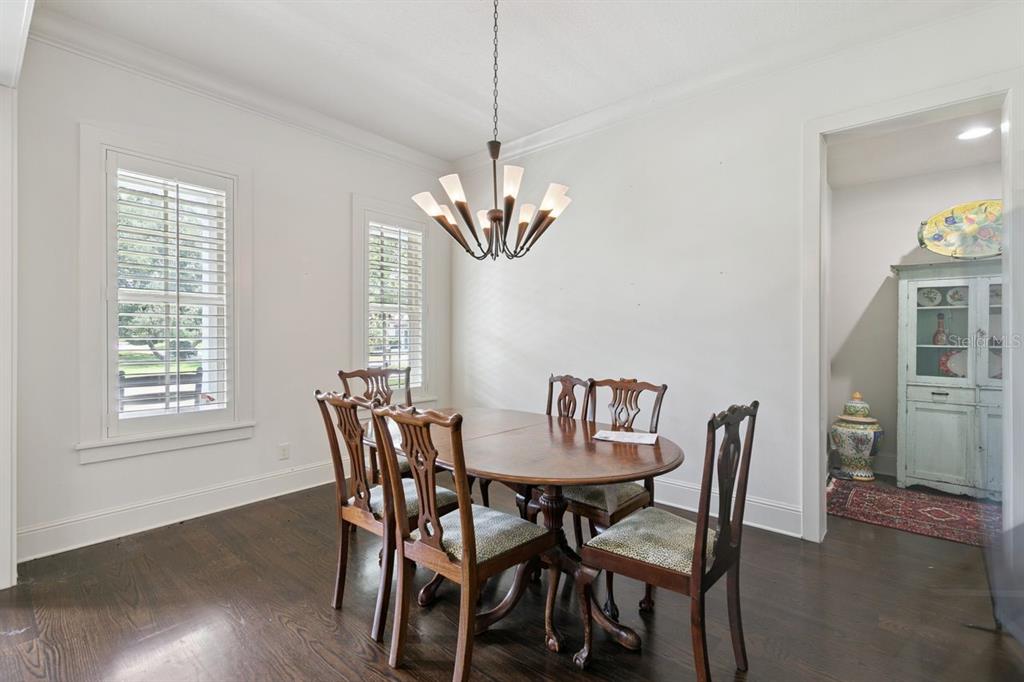 A dining room features a wooden table, four chairs, a chandelier, and dark hardwood floors — 2240 VENETIAN WAY, WINTER PARK, FL