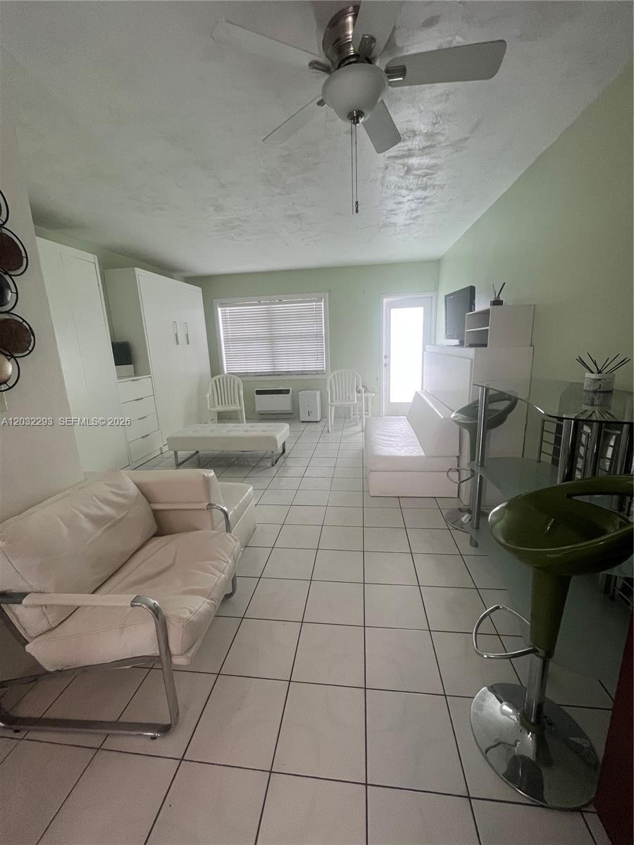 This living room features white tile flooring, a ceiling fan, and white furniture — 851 Meridian Ave # 44, Miami Beach FL 33139, MIAMI BEACH, FL