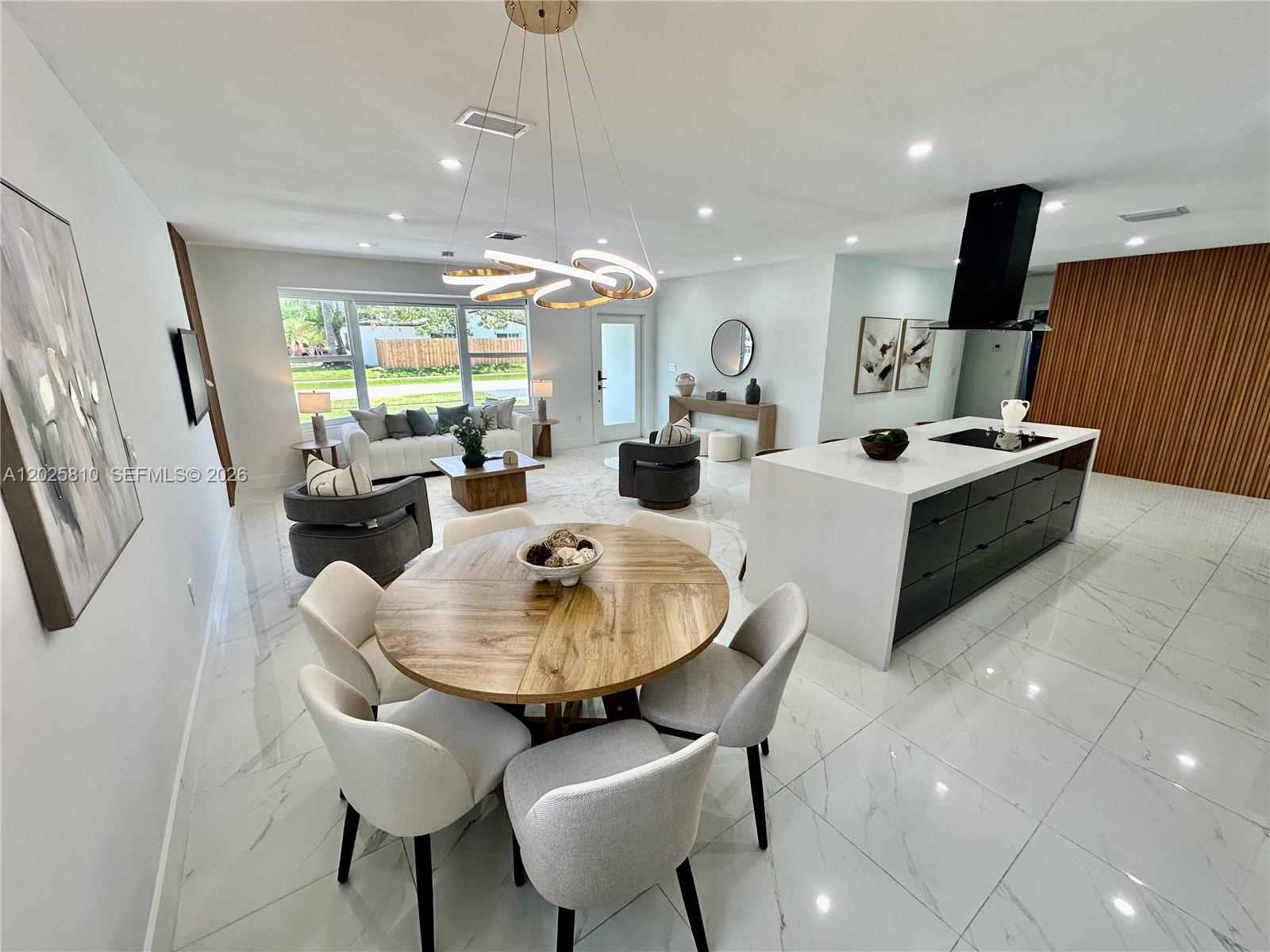 An open-concept living and dining area features white marble floors and a modern kitchen island — 1446 Scott St, Hollywood FL 33020, HOLLYWOOD, FL