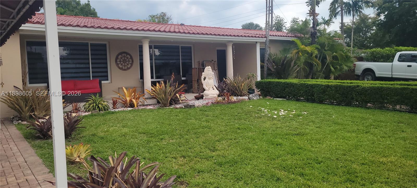 The exterior of a single-story house features a red tile roof and a front lawn — SOUTH MIAMI, FL
