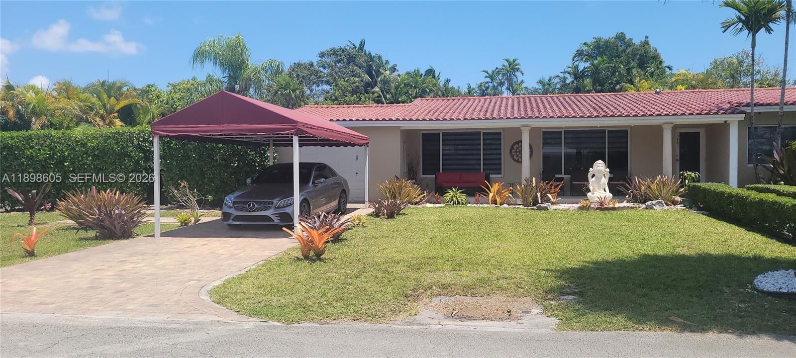 A single-story house with a red tile roof, a maroon carport, and a front lawn — SOUTH MIAMI, FL