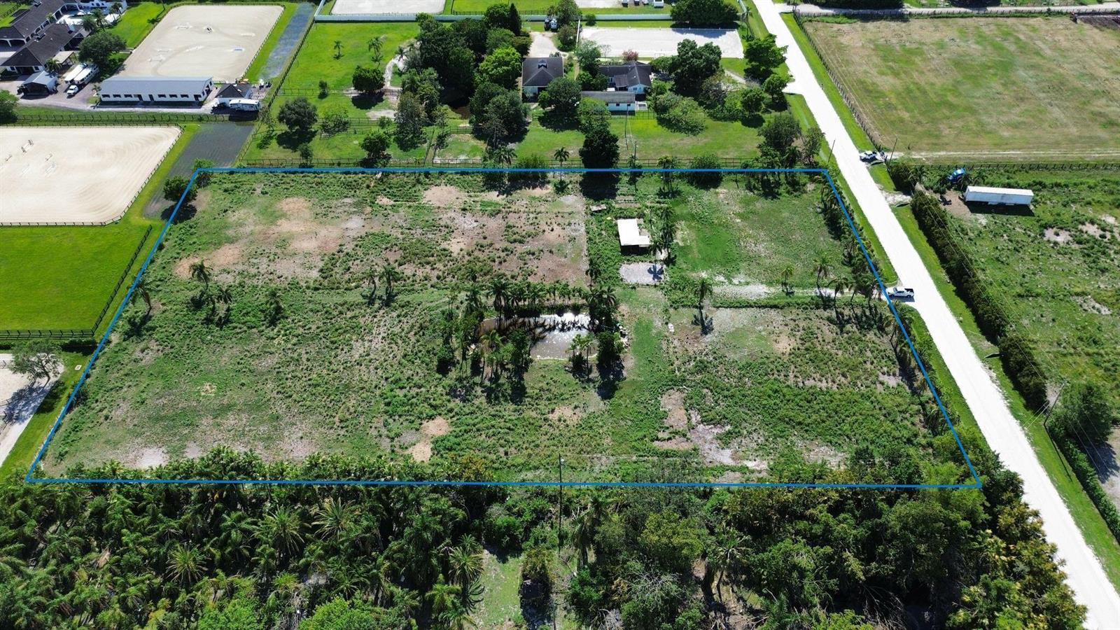 An aerial view shows a large, rectangular, undeveloped plot of land outlined in blue — 16290 Rustic Road, Wellington FL 33470, WELLINGTON, FL