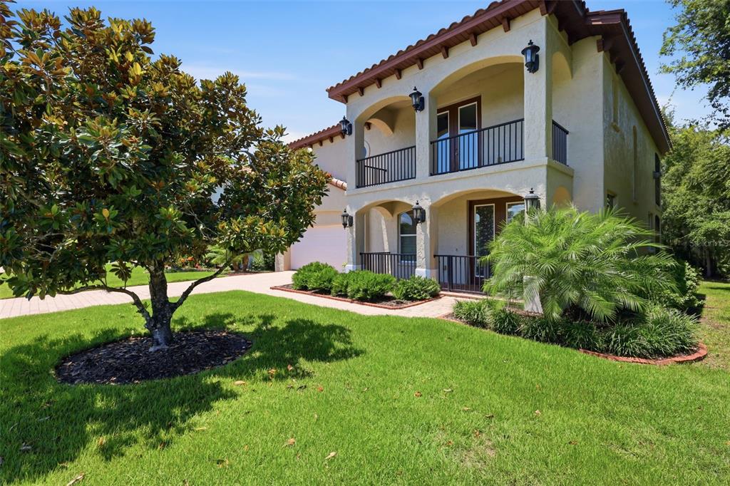 A two-story stucco house with a tiled roof, arched balconies, and a landscaped front yard — 750 ONYX PARKWAY, DELAND, FL