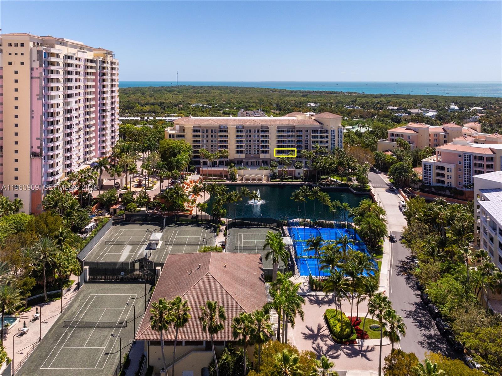 An aerial view shows a large residential complex with tennis courts, a lake, and palm trees — 765 Crandon Blvd # 306, Key Biscayne FL 33149, KEY BISCAYNE, FL