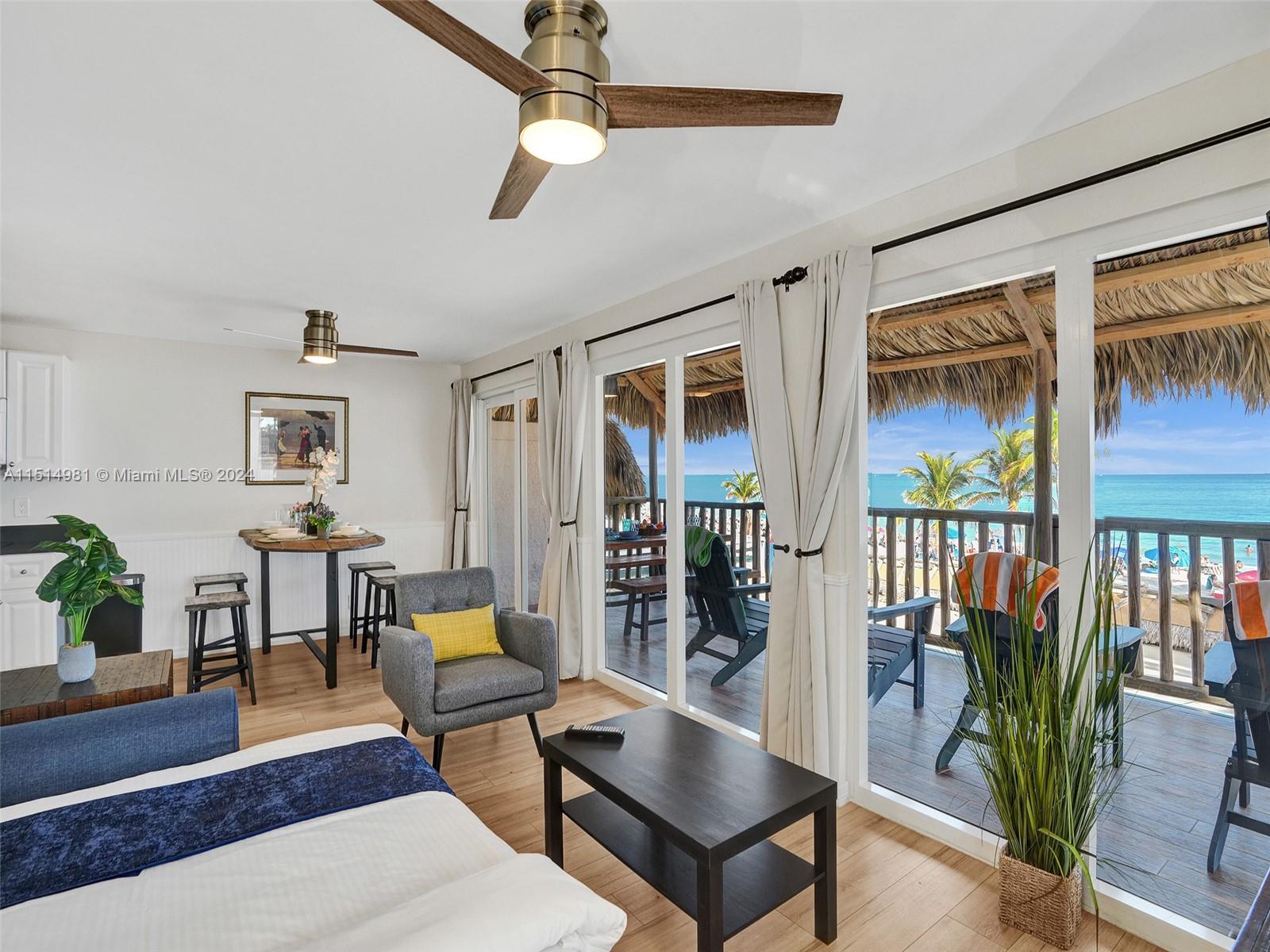 A bedroom features a ceiling fan, a small dining area, and sliding doors opening to a balcony — 900 N Surf Rd # 2, Hollywood FL 33019, HOLLYWOOD, FL