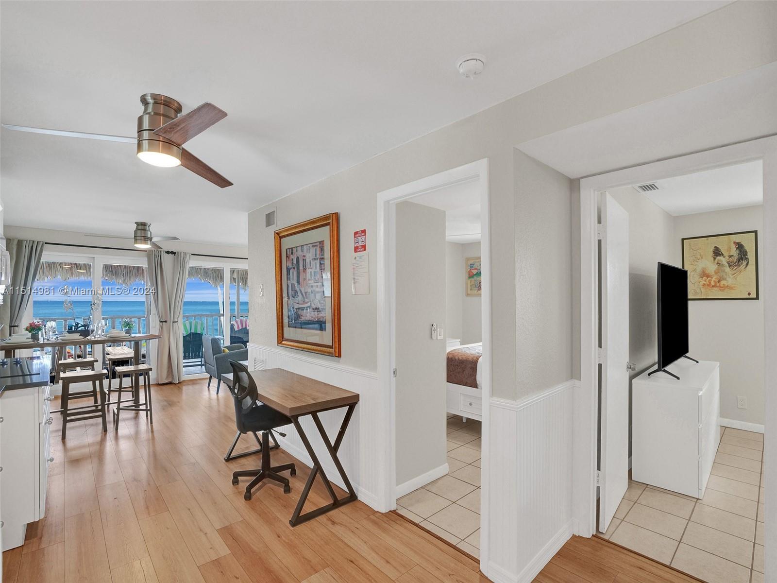 An interior view shows a living area with a desk, ocean view, and two doorways — 900 N Surf Rd # 2, Hollywood FL 33019, HOLLYWOOD, FL