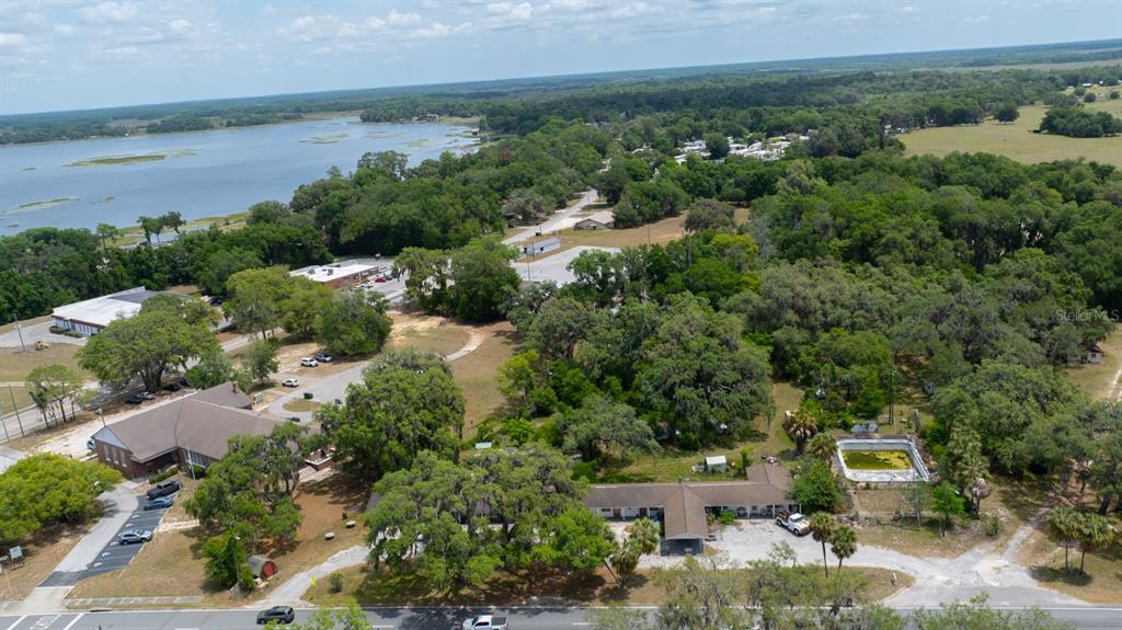An aerial view shows a low-rise building with a pool near a large lake — 2355 N FLORIDA AVENUE, HERNANDO, FL