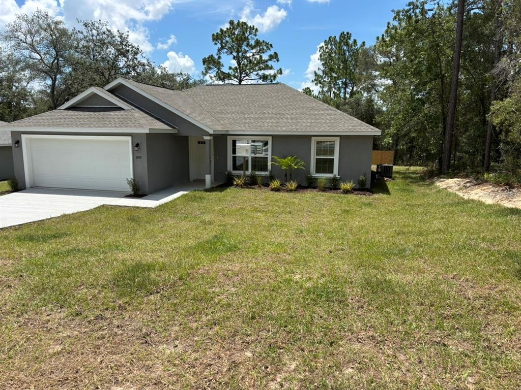 A single-story gray house with a two-car garage and a front lawn — 1808 W LINDEN DRIVE, DUNNELLON, FL