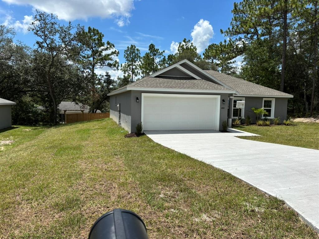 A gray single-story house with a white garage door and a concrete driveway — 1808 W LINDEN DRIVE, DUNNELLON, FL