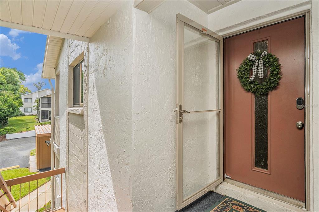 A view of an exterior entryway featuring a brown front door with a wreath — 12308 EAGLESWOOD DRIVE UNIT D, HUDSON, FL