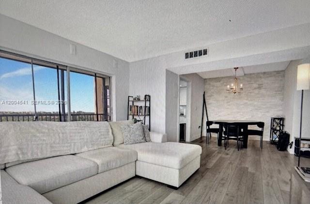 A living room with a sectional sofa, wood-look flooring, and an adjacent dining area — 4174 Inverrary Dr # 914, Lauderhill FL 33319, LAUDERHILL, FL