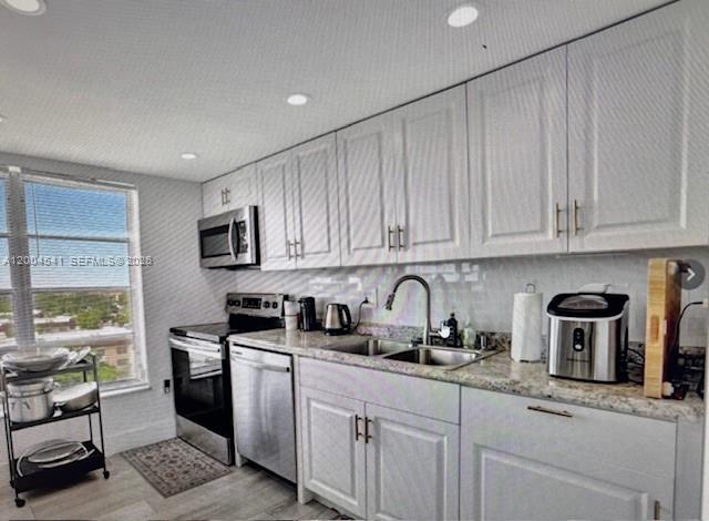 A kitchen featuring white cabinets, stainless steel appliances, granite countertops, and a window with views — 4174 Inverrary Dr # 914, Lauderhill FL 33319, LAUDERHILL, FL