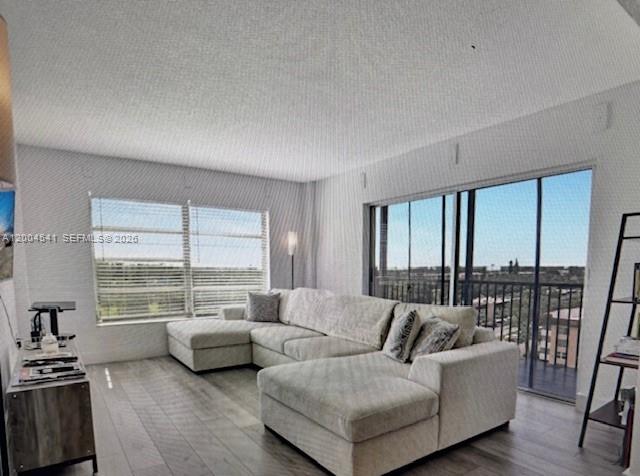 A living room features a large sectional sofa, light wood flooring, and a sliding glass door — 4174 Inverrary Dr # 914, Lauderhill FL 33319, LAUDERHILL, FL