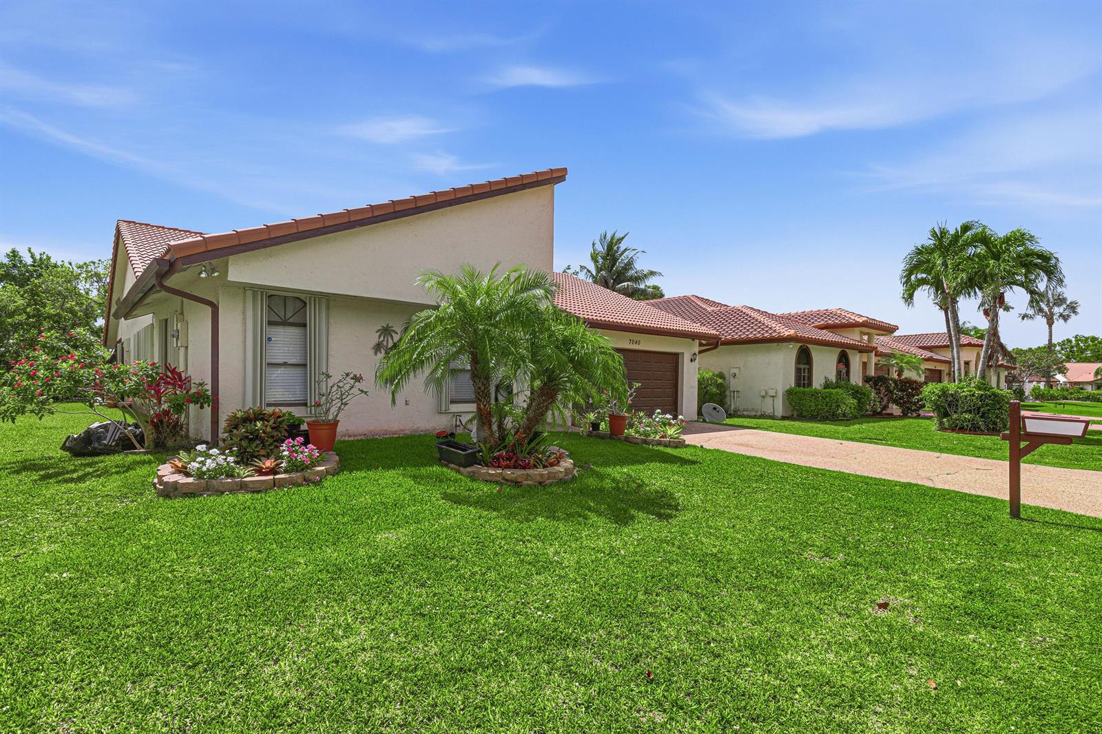 A single-story house with a slanted roof, a palm tree, and a green lawn — 7040 Golf Pointe Circle, Tamarac FL 33321, TAMARAC, FL