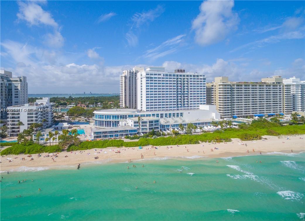 An aerial view of a beachfront resort complex with multiple high-rise buildings and sandy shores — 5445 Collins Ave # 1135, Miami Beach FL 33140, MIAMI BEACH, FL