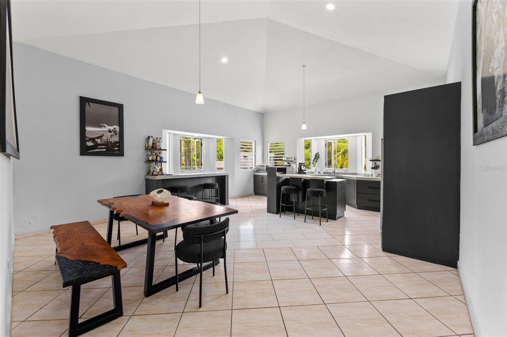 A modern open-concept kitchen and dining area features a live-edge table and tiled floors — Lote 30 BARRIO ENSENADA, RINCON, PR