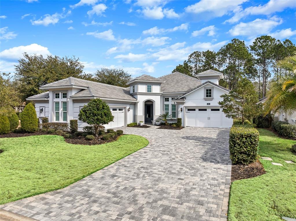 A single-story house with a paver driveway, white stucco exterior, and a multi-car garage — 241 CONSERVATORY DRIVE, PALM COAST, FL