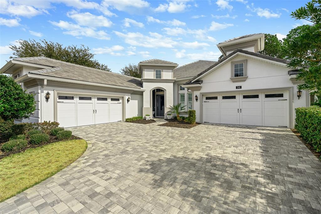 A single-story house with a paved driveway, two garages, and a central entryway — 241 CONSERVATORY DRIVE, PALM COAST, FL
