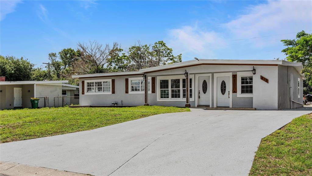 A single-story house with a gray exterior, two front doors, and a concrete driveway — 815 W HIGHLAND DRIVE, COCOA, FL